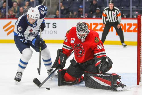 Kristian Reichel tries to get the puck past Rockford's Arvid Soderblom. (Daniel Crump / Winnipeg Free Press)