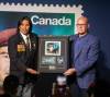 Tommy Prince Jr. (left) is presented with a stamp of his father, Sgt. Tommy Prince, at the Canadian Museum for Human Rights. (Jessica Lee / Winnipeg Free Press)