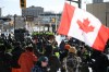 Protesters face police officers on foot and horseback and an armoured vehicle on Colonel By Drive near the truck blockade in Ottawa, on Friday, Feb. 18, 2022. THE CANADIAN PRESS/Justin Tang