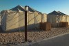 Accommodation tents are seen at a camp site in Al Khor, Qatar, Wednesday, Nov. 23, 2022. For scores of foreign soccer fans, the road to the World Cup in Doha starts every morning at a barren campsite in the middle of the desert. Visitors who found hotels in central Doha booked up or far beyond their budget have settled for the faraway, dust-blown tent village in Al Khor, where there are no locks on tents nor beers on draft. (AP Photo/Jon Gambrell)