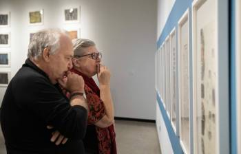 JESSICA LEE / WINNIPEG FREE PRESS The Winnipeg Free Press 150th exhibit opening night at the Winnipeg Art Gallery is photographed November 30, 2022. Liliane Trembley (in red) and Fletcher Smith look at old layouts. Reporter: ??