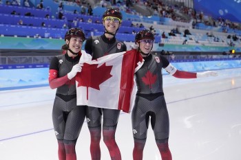 Team Canada's Valerie Maltais, left, Isabelle Weidemann and Ivanie Blondin, right, pose with the Canadian flag after winning the gold medal and setting an Olympic record in the speedskating women's team pursuit at the 2022 Winter Olympics, Tuesday, Feb. 15, 2022, in Beijing. THE CANADIAN PRESS/AP-Sue Ogrocki