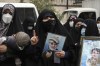 An Iranian woman holds a portrait of the late Revolutionary Guard Gen. Qassem Soleimani, who was killed in Iraq in a U.S. drone attack in 2020, in a pro-government demonstration in front of the United Nation's office in Tehran, Iran, Tuesday, Dec. 13, 2022. The demonstrators condemned calls for the Islamic Republic to be expelled from the UN Commission on the Status of Women by other member countries, following Iranian security forces' continued crackdown on anti-government protests sparked by the death of a women after she was arrested by the country's morality police in September. (AP Photo/Vahid Salemi)