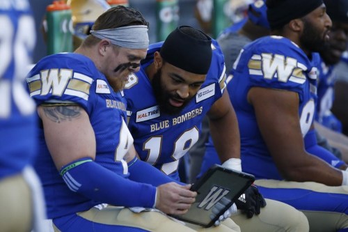 Winnipeg Blue Bombers linebackers Adam Bighill (4) and Kyrie Wilson (19) look at film during the first half of CFL action against the Edmonton Eskimos in Winnipeg Friday, May 31, 2019. The Winnipeg Blue Bombers have signed Wilson to a one-year contract extension. THE CANADIAN PRESS/John Woods