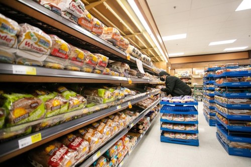 A worker re-stocks shelves in the bakery and bread aisle at an Atlantic Superstore in Halifax, N.S., on Friday, Jan. 28, 2022. How those wheat kernels end up in a loaf of bread -- and why prices have risen this year -- is an odyssey involving growers and grain handlers, rail cars and flour mills, and bakeries and supermarkets. THE CANADIAN PRESS/Kelly Clark