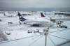 Aircraft are seen parked at gates at Vancouver International Airport after a snowstorm impaired operations leading to cancellations and major delays, in Richmond, B.C., on Tuesday, December 20, 2022. THE CANADIAN PRESS/Darryl Dyck