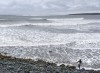 A surfer heads to the water in Cow Bay, N.S., on Tuesday, Nov. 23, 2021. The East Coast is going through a stormy prelude to Christmas Eve, as a mix of heavy rainfall and powerful gusts are beginning today and carrying on through the night. THE CANADIAN PRESS/Andrew Vaughan