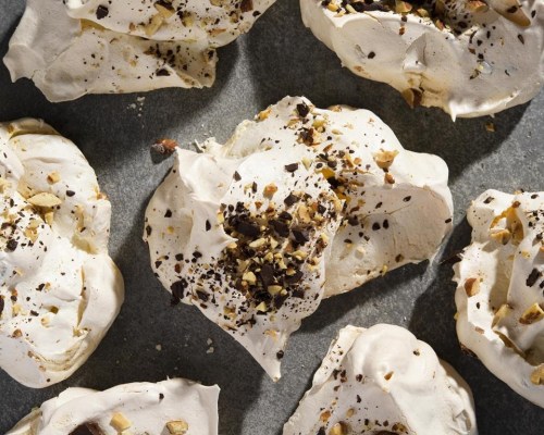 This image released by Milk Street shows a recipe for meringue cookies topped with salted peanuts and chocolate. (Milk Street via AP)