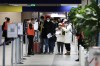 Passengers arriving from China wait in front of a COVID-19 testing area set at the Roissy Charles de Gaulle airport, north of Paris, Sunday, Jan. 1, 2023. France says it will require negative COVID-19 tests of all passengers arriving from China and is urging French citizens to avoid nonessential travel to China. (AP Photo/Aurelien Morissard)