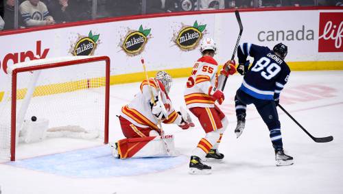 Sam Gagner deflects a Ville Heinola shot past Calgary goaltender Jacob Markstrom for the winning goal in the third period on Tuesday. (Fred Greenslade / The Canadian Press)