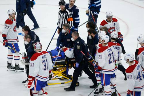 JOHN WOODS / THE CANADIAN PRESS FILES
                                Montreal Canadiens player Jake Evans is stretchered off the ice at the end of a 2021 playoff game against the Jets in Winnipeg.