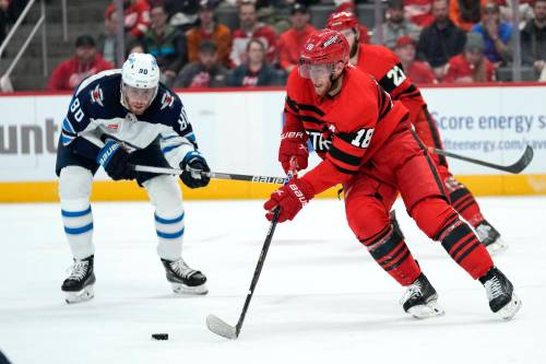 Former Winnipeg Jet Andrew Copp is chased by Pierre-Luc Dubois in the third period on Tuesday. (Paul Sancya / The Associated Press)