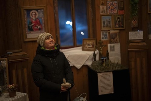 Maria Kharcheva, a school teacher who recently moved from Russia, looks at icons in the Orthodox chapel during Orthodox Christmas in Barentsburg, Norway, Saturday, Jan. 7, 2023. 