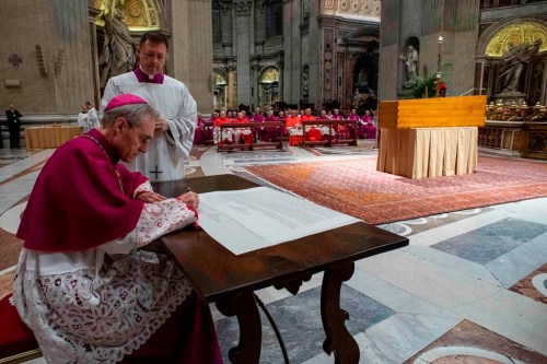 In this image released on Thursday, Jan. 5, 2023, by the Vatican Media news service, Bishops Georg Gaenswein signs the 