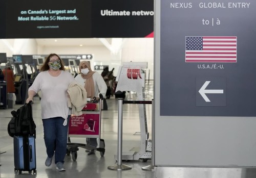 People travel to the United States of America at Pearson International Airport in Toronto, Friday, Dec. 3, 2021. Air Canada warned travellers to check their flights before heading to the airport as troubles caused by a key computer outage at the U.S. Federal Aviation Administration caused delays. THE CANADIAN PRESS/Nathan Denette