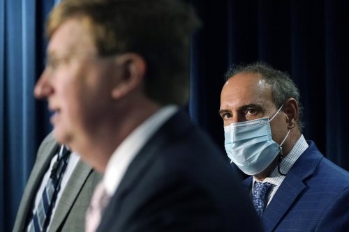 FILE - State Epidemiologist Dr. Paul Byers, right, listens to Mississippi Gov. Tate Reeves, left, at a news briefing, Aug. 24, 2021, in Jackson, Miss. The state's Department of Health said Wednesday, Jan. 11, 2023, that the 14th Mississippi child has died from COVID-19. (AP Photo/Rogelio V. Solis, File)