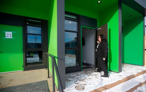 Melissa Stone, co-ordinator of Astum Api Niikinaahk, enters one of the accessible rooms in the tiny house village that just opened for homeless in downtown Winnipeg, Thursday, Dec. 1, 2022. The small village of 22 units and a community lodge has been in the works for the past two years and opened to residents this week. THE CANADIAN PRESS/John Woods