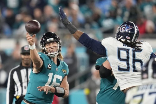 Jacksonville Jaguars quarterback Trevor Lawrence (16) passes under pressure from Tennessee Titans defensive end Denico Autry (96) in the second half of an NFL football game, Saturday, Jan. 7, 2023, in Jacksonville, Fla. (AP Photo/John Raoux)