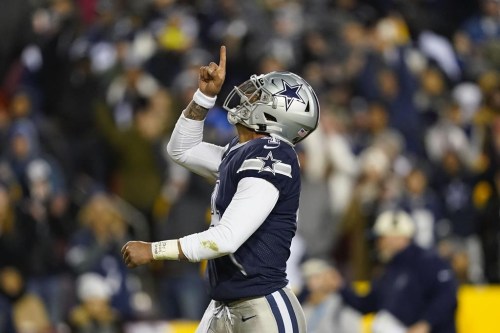 Dallas Cowboys quarterback Dak Prescott (4) points upward after scoring against Washington Commanders during the first half an NFL football game, Sunday, Jan. 8, 2023, in Landover, Md. (AP Photo/Patrick Semansky)