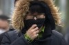 A commuter wearing a face mask walks along a street in the central business district in Beijing, Thursday, Jan. 12, 2023. (AP Photo/Mark Schiefelbein)