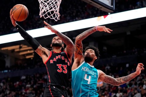 Toronto Raptors guard Gary Trent Jr. (33) gets his shot off as Charlotte Hornets centre Nick Richards (4) defends under the basket during first half NBA basketball action in Toronto on Thursday, Jan. 12, 2023. THE CANADIAN PRESS/Frank Gunn