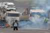 A protester kneels with his hands behind his head as riot police launch tear gas at truckers blocking a highway in protest against President Jair Bolsonaro's loss in the country's presidential runoff election, in Embu das Artes, outskirts of Sao Paulo, Brazil, Tuesday, Nov. 1, 2022.  Since the former President Luiz Inacio Lula da Silva's victory Sunday night, many truck drivers have jammed traffic in areas across the country and said they wonâ€™t acknowledge Bolsonaroâ€™s defeat. Bolsonaro hasnâ€™t spoken publicly since official results were released roughly 36 hours ago, nor phoned da Silva to concede. (AP Photo/Andre Penner)