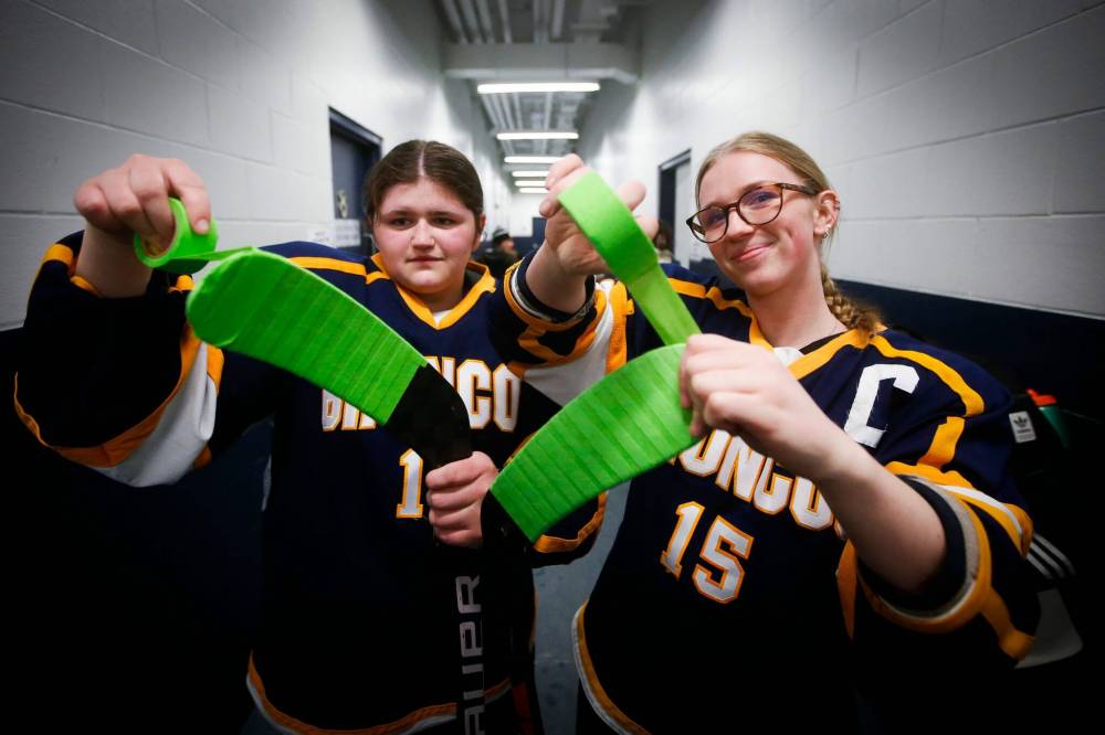 JOHN WOODS / WINNIPEG FREE PRESS
                                JH Bruns Broncos&rsquo; Kadence Morin, left, and Emma-Rae Wallis prep their sticks prior to puck drop.