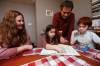 JOHN WOODS / WINNIPEG FREE PRESS
                                Jane Friesen and Ulises Cancino, who is from Chile, look over some spanish books with their children Noa, 6, and Ian, 10, in their home.