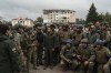 FILE - Ukrainian President Volodymyr Zelenskyy stands with soldiers after attending a national flag-raising ceremony in the freed Izium, Ukraine, Wednesday, Sept. 14, 2022. A year ago, with Russian forces bearing down on Ukraine’s capital, Western leaders feared for the life of President Volodymyr Zelenskyy and the U.S. offered him an escape route. Zelenskyy declined, declaring his intent to stay and defend Ukraine’s independence. (AP Photo/Leo Correa, File)