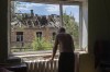 FILE - Victor Rosenberg, 81, looks out of a broken window in his home destroyed by the Russian rocket attack in the city centre of Bakhmut, Donetsk region, Ukraine, Friday, July 1, 2022. New video footage of Bakhmut shot from the air with a drone for The Associated Press shows how the longest battle of the year-long Russian invasion has turned the city of salt and gypsum mines in eastern Ukraine into a ghost town. (AP Photo/Efrem Lukatsky, File)