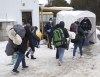 A family of asylum seekers from Colombia is met by RCMP officers after crossing the border at Roxham Road into Canada from Champlain, New York, Thursday, Feb. 9, 2023. Immigration advocates say they are disappointed that Canada and the U.S. have agreed to restrict the flow of asylum seekers across their shared border. THE CANADIAN PRESS/Ryan Remiorz