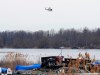 A police helicopter searches the area in Akwesasne, Que., Friday, March 31, 2023. Authorities in the Mohawk Territory of Akwesasne say the bodies of eight migrants of Indian and Romanian descent were pulled from the river Thursday. THE CANADIAN PRESS/Ryan Remiorz