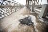 MIKAELA MACKENZIE / WINNIPEG FREE PRESS
                                A man is suing the city after he says he injured his leg when his foot got caught in a hole in an access cover in the sidewalk of the Louise Bridge.