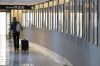 FILE - A traveler pulls their luggage between terminals at Logan International Airport, Wednesday, Jan. 11, 2023, in Boston. Travel prices are high and young Americans remain eager to vacation. Yet looming economic and personal finance trends point to trouble ahead. Millennials and Generation Z are racking up credit card debt and falling behind on payments, and many are turning to “buy now, pay later” plans to fund travel. (AP Photo/Steven Senne, File)