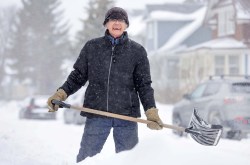 Terry Lane, 83, finds lots to still smile about as he shovels the sidewalk in front of his home on Valour Road. (Ruth Bonneville / Winnipeg Free Press)