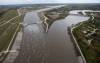 The Winnipeg Floodway outlet (left) and the Red River just north of Winnipeg. (The Canadian Press files / John Woods)