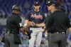 Atlanta Braves starting pitcher Dylan Dodd watches as three MLB umpires approach the mound during the first inning of a baseball game against the Miami Marlins, Thursday, May 4, 2023, in Miami. (AP Photo/Marta Lavandier)