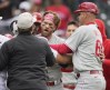 Philadelphia Phillies' Bryce Harper, center left, is restrained by first base umpire Ben May, front left, and Phillies third base coach Dusty Wathan, right, after reacting to a taunt at the Phillies dugout by Colorado Rockies relief pitcher Jake Bird in the seventh inning of a baseball game Sunday, May 14, 2023, in Denver. (AP Photo/David Zalubowski)