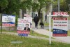 Canada Mortgage and Housing Corp. says the country's residential mortgage debt increased six per cent from last year to $2.08 trillion. A person walks past multiple for-sale and sold real estate signs in Mississauga, Ont., on Wednesday, May 24, 2023. THE CANADIAN PRESS/Nathan Denette