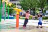 MIKAELA MACKENZIE / WINNIPEG FREE PRESS
 Lake Fox (left, four) and his brother Luxton (one) Komaransky cool off at the splash pad in Central Park on Friday.