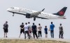 People look on as an Air Canada plane takes off at Trudeau Airport in Montreal, Sunday, June 11, 2023. Air Canada pilots are kickstarting the process to begin talks with their employer, days after their fellow union members at WestJet ratified a new collective agreement.&nbsp;THE CANADIAN PRESS/Graham Hughes