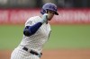 Chicago Cubs' Ian Happ points to his dugout as he rounds third base on a solo home run during the third inning of a baseball game against the St. Louis Cardinals Saturday, June 24, 2023, in London. (AP Photo/Kin Cheung)