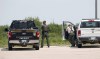 Conservation officers watch over a stand of trees Sunday afternoon for a coyote that mauled a small boy on Knowles Avenue Saturday night. (John Woods / Winnipeg Free Press)