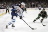 Winnipeg Jets center Morgan Barron, left, skates with the puck alongside Minnesota Wild defenseman Jon Merrill during the second period of an NHL hockey game&nbsp;in St. Paul, Minn., on&nbsp;April 11, 2023. THE CANADIAN PRESS/AP, Abbie Parr