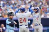 Toronto Blue Jays catcher Alejandro Kirk looks on as Chicago Cubs shortstop Dansby Swanson (7) celebrates after hitting a three run homer with teammate Cody Bellinger (24) during fourth inning MLB interleague baseball action against the Toronto Blue Jays, in Toronto, Saturday, Aug. 12, 2023. THE CANADIAN PRESS/Chris Young
