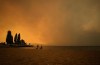 Thousands of people have been ordered to evacuate from West Kelowna and the Westbank First Nation due to the nearby MacDougall Creek wildfire that has destroyed a significant number of properties. Smoke from the McDougall Creek wildfire fills the air and nearly blocks out the sun as people take in the view of Okanagan Lake from Tugboat Beach, in Kelowna, B.C., Friday, Aug. 18, 2023. THE CANADIAN PRESS/Darryl Dyck