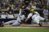 Miami Marlins' Jake Burger, left, is tagged out at home by San Diego Padres catcher Gary Sanchez, trying to score from second base off a single by Jazz Chisholm Jr. during the third inning of a baseball game Tuesday, Aug. 22, 2023, in San Diego. (AP Photo/Gregory Bull)