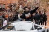 FILE - San Francisco Giants catcher Buster Posey and his wife, Kristen, ride in a car as confetti falls during the baseball team's World Series victory parade, Oct. 31, 2012, in San Francisco. Posey, the retired Giants catcher, has a year's worth of coursework remaining to complete his degree in social science at Florida State, yet he plans to spend the next two years finishing up given his busy home life with four children. (AP Photo/Jeff Chiu, File)