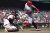 Cincinnati Reds' Christian Encarnacion-Strand, right, hits a two-run home run in front of San Francisco Giants catcher Patrick Bailey during the eighth inning of a baseball game in San Francisco, Wednesday, Aug. 30, 2023. (AP Photo/Jeff Chiu)