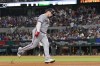 Minnesota Twins' Christian Vazquez celebrates after his solo home run as he rounds third base in the seventh inning of a baseball game against the Texas Rangers, Friday, Sept. 1, 2023, in Arlington, Texas. (AP Photo/Tony Gutierrez)